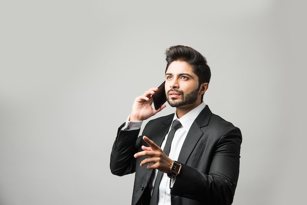 Indian business man using cell phone. Having Conversation, typing sms or presenting