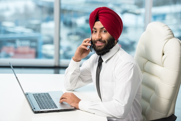 Indian businessman is working on his computer in the office.