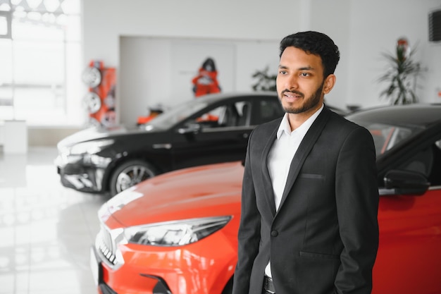 Indian cheerful car salesman at showroom