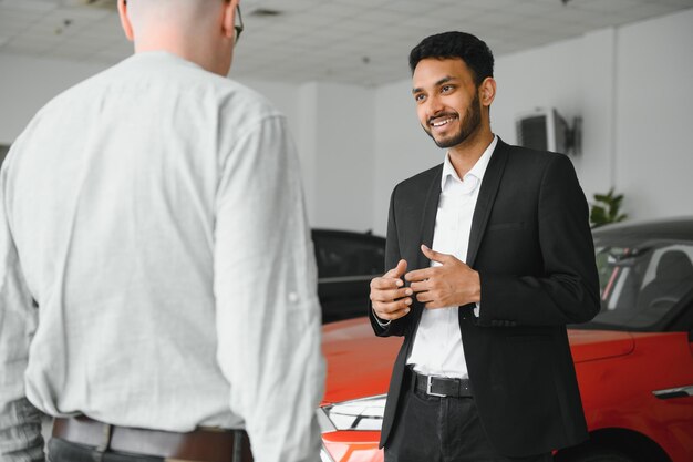 Indian cheerful car salesman at showroom