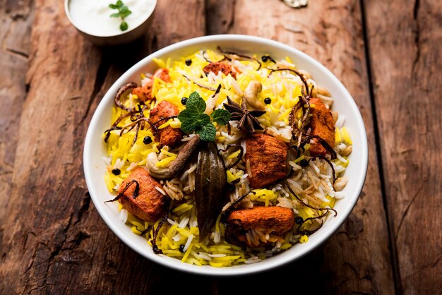 인도 치킨 티카 비리야니는 요구르트와 함께 그릇에 제공됩니다. 선택적 초점