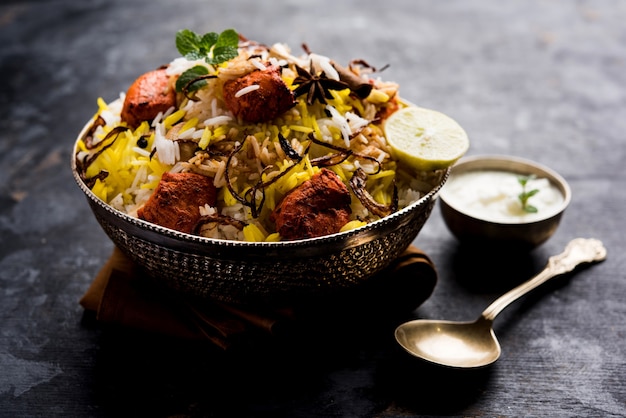 Foto indian chicken tikka biriyani servito in una ciotola con yogurt