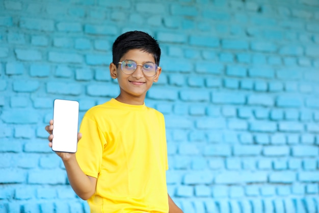 Indian child showing smartphone screen. online education concept