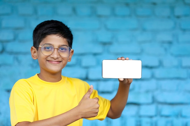 Indian child showing smartphone screen. online education concept