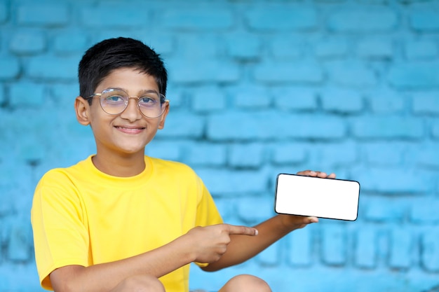 Indian child showing smartphone screen. online education concept