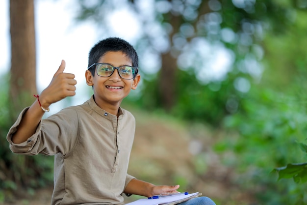 Indian child wearing spectacles and showing thumbs up