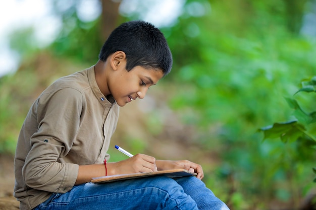 Indian child writing on note book