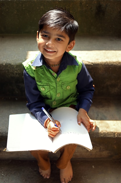 Indian child writing on note book