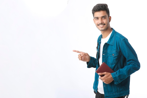 Indian college boy showing diary on white background.