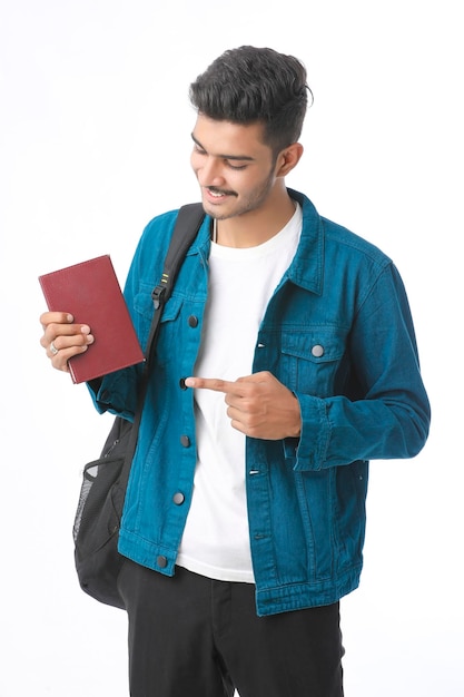 Indian college boy showing diary on white background.