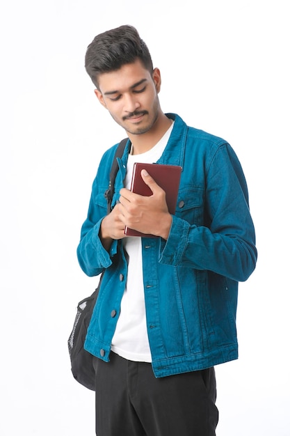 Indian college boy showing diary on white background.