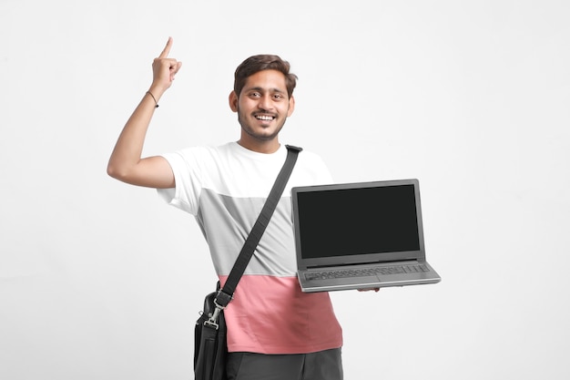 Indian college student showing laptop screen on white background.