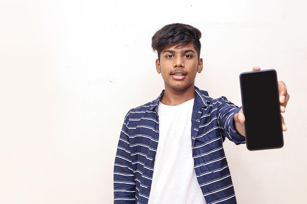 Индийский студент колледжа показывает мобильный экран на белом фоне