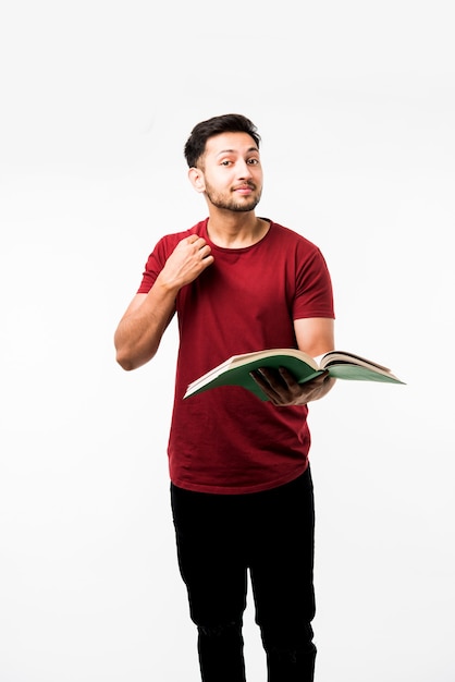 Indian college student with book, reading or showing victory cup, award while standing isolated over white background