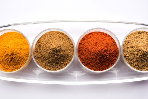 Indian colourful spices. group photo of four basic indian spices like raw red chilli, turmeric, coriander and cumin powder. selective focus