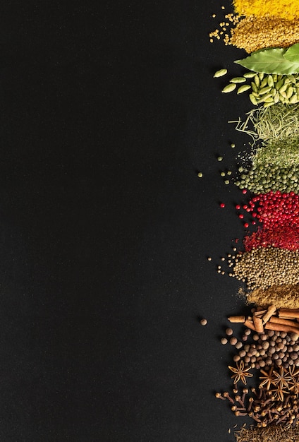 Indian condiments on black table in high resolution Spices for cooking food on background of chalkboard with empty space