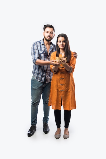 Indian couple holding gold jewelry, ornaments 