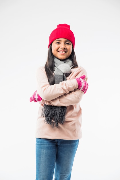 Indian cute little girl in winter wear, standing against white background