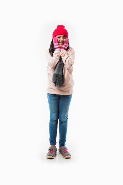 Photo indian cute little girl in winter wear, standing against white background