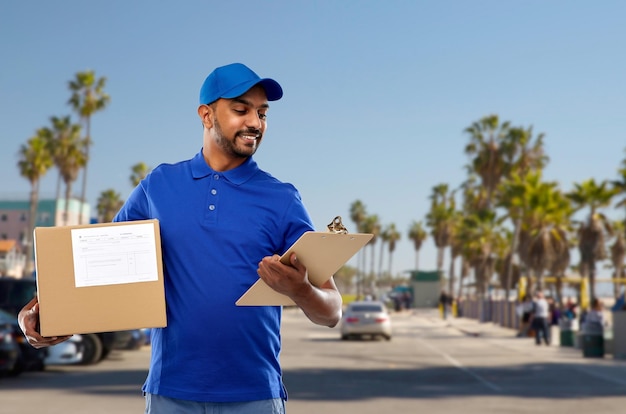 indian delivery man with parcel box and clipboard