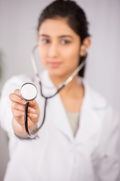 Indian doctor wearing a white coat with stethoscope.