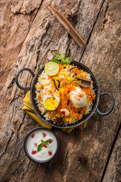 Indian Egg Biryani of anda rijst geserveerd in kadhai of kadai met yoghurtdip, selectieve focus