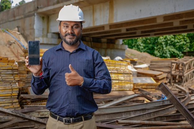 Индийский инженер, держащий мобильный телефон, отправляет сообщение, интернет-технологии, инженер, строительная инспекция, строительный проект