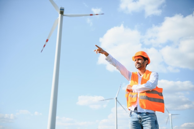 Indian Engineer in wheat field checking on turbine production