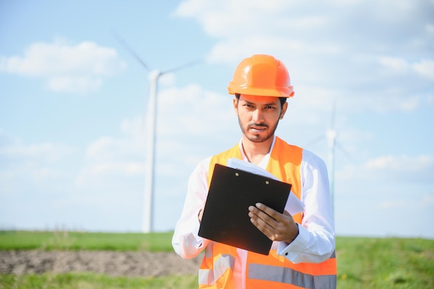 Indian Engineer working at alternative renewable wind energy farm Sustainable energy industry concept