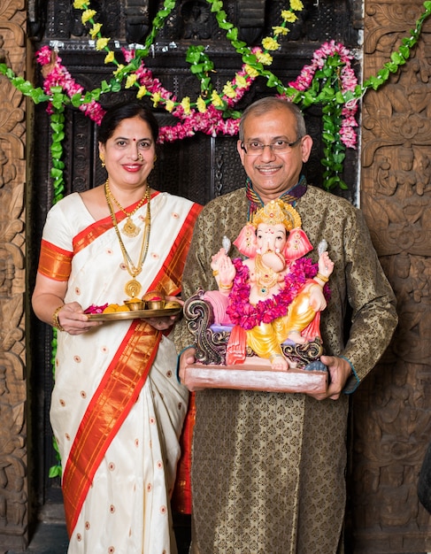 Indian Family celebrating Ganesh Chaturthi by doing Ganpati Puja or poojan