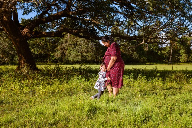 Indian family of mother and toddler in a garden and in anticipation of a second child