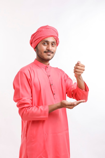 Indian farmer holding wheat in his hand and smiling.