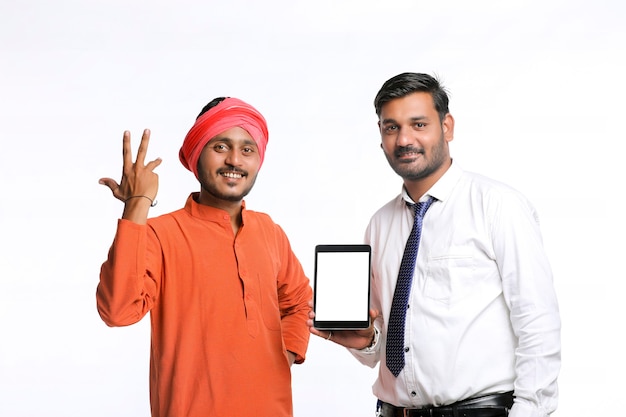 인도 농부는 흰색 바탕에 은행 직원이나 기업 정부 직원과 함께 태블릿을 보여줍니다.