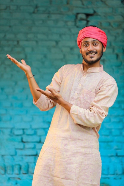 Foto contadino indiano in abiti tradizionali e che dà un'espressione felice a casa