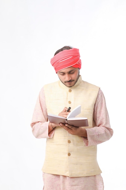 Indian farmer using diary on white background.