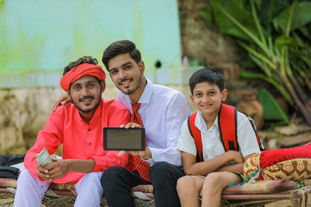 Indian farmer with his schoolboy and a banker in the countryside