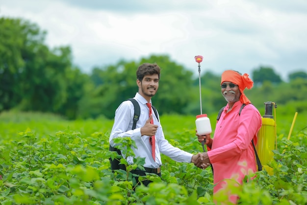 Indian farmer with salesman at field