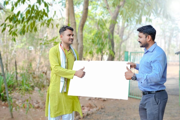 Indian farmer with young indian banker at home yard