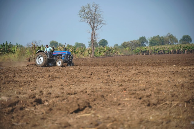 Photo indian farmer working with tractor in agriculture field.