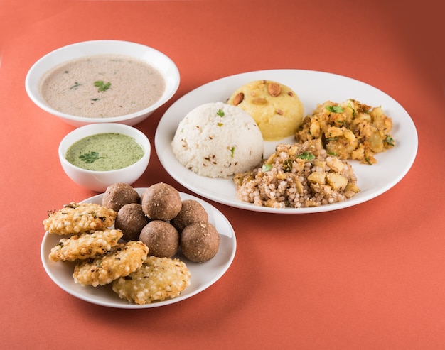 Photo indian fasting recipes or upwas food, for navratri , maha shivratri or ekadasi or chaturthi or gauri vrat. served in ceramic crockery over colourful or wooden background. selective focus