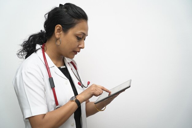 흰색 코트 모자와 태블릿 원격 진료 온라인 상담을 가진 30 대 인도 여성 의사