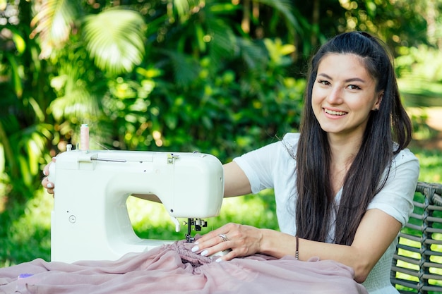 Indian female sewing outdoors in summer park