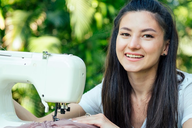 Indian female sewing outdoors in summer park