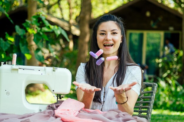 Indian female sewing outdoors in summer park