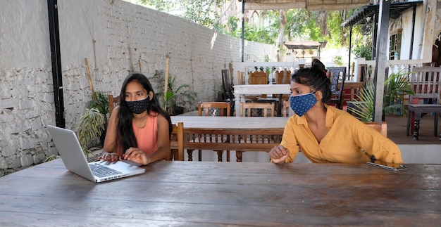 COVID-19 대유행 동안 사회적 거리를 유지하며 소통하는 안면 마스크를 쓴 인도 여성