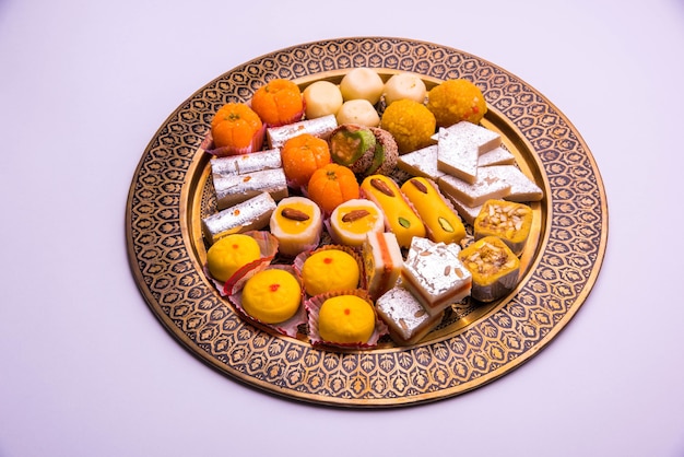 白い背景に甘い食べ物やミタイを盛り合わせたインドのお祭り