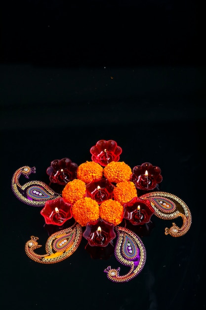 Indian festival diwali ,marigold flower and Colorful lamps of oil on black background