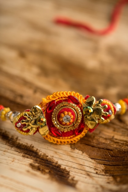 Indian festival: Raksha Bandhan background with an elegant Rakhi, Rice Grains and Kumkum