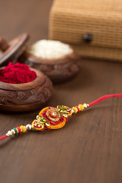 인도 축제 : 우아한 Rakhi, Rice Grains 및 Kumkum이있는 Raksha Bandhan 배경