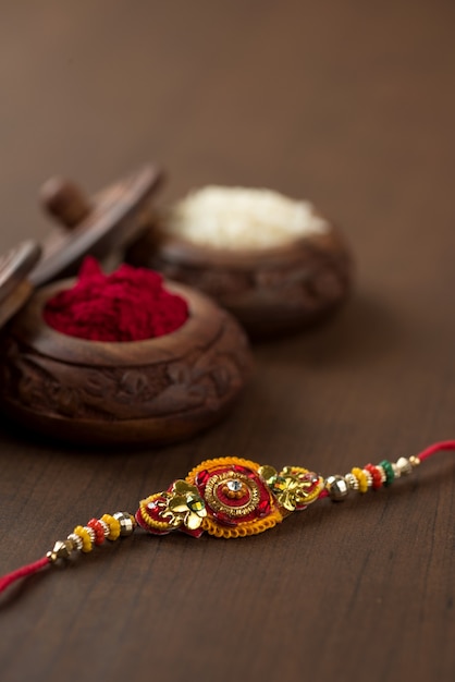 인도 축제 : 우아한 Rakhi, Rice Grains 및 Kumkum이있는 Raksha Bandhan 배경